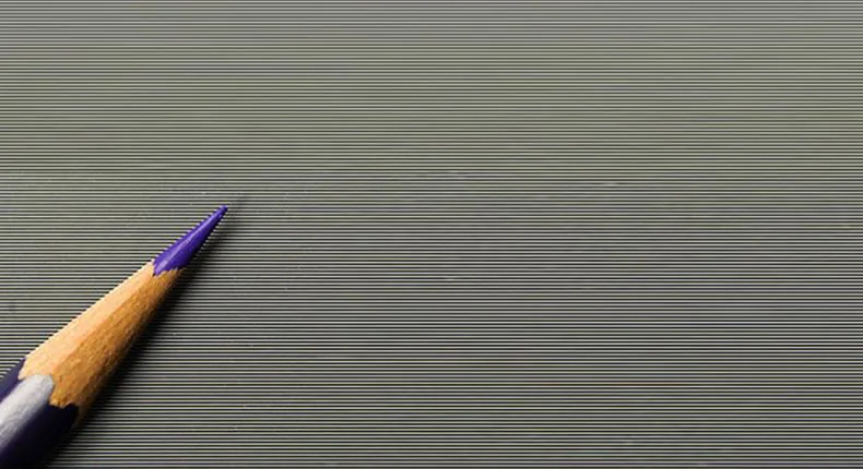 Macro of the lenticular ALR surface, horizontal prisms shown against a pencil tip for scale